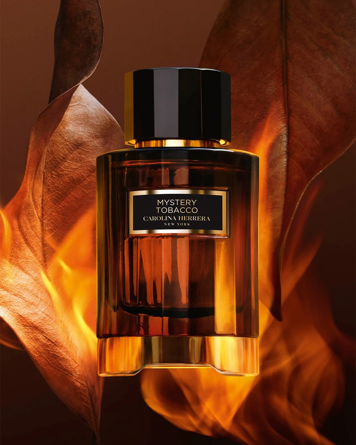 Carolina Herrera Mystery Tobacco bottle against warm amber fabric