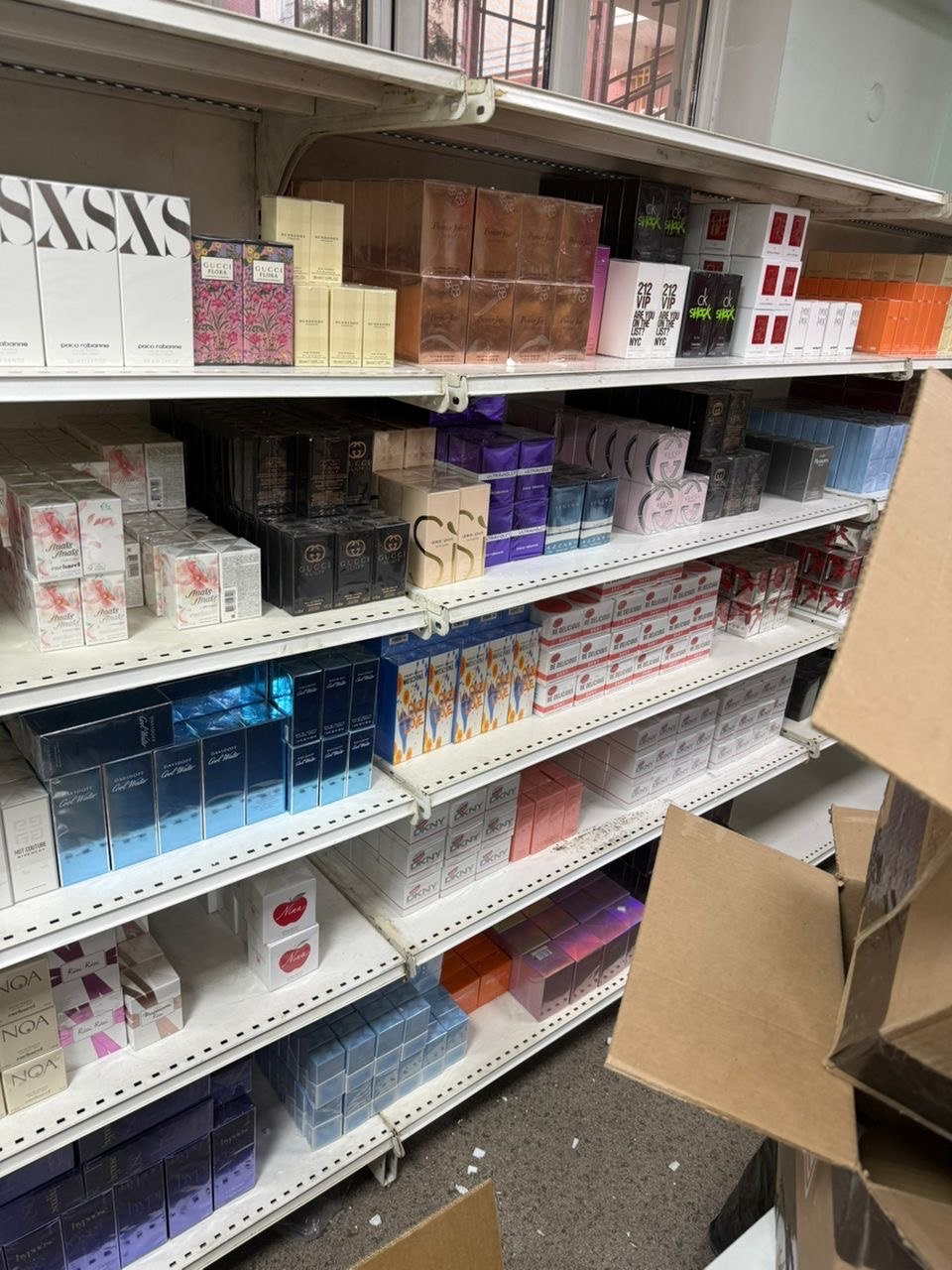 Multiple perfume ranges stored on warehouse shelving